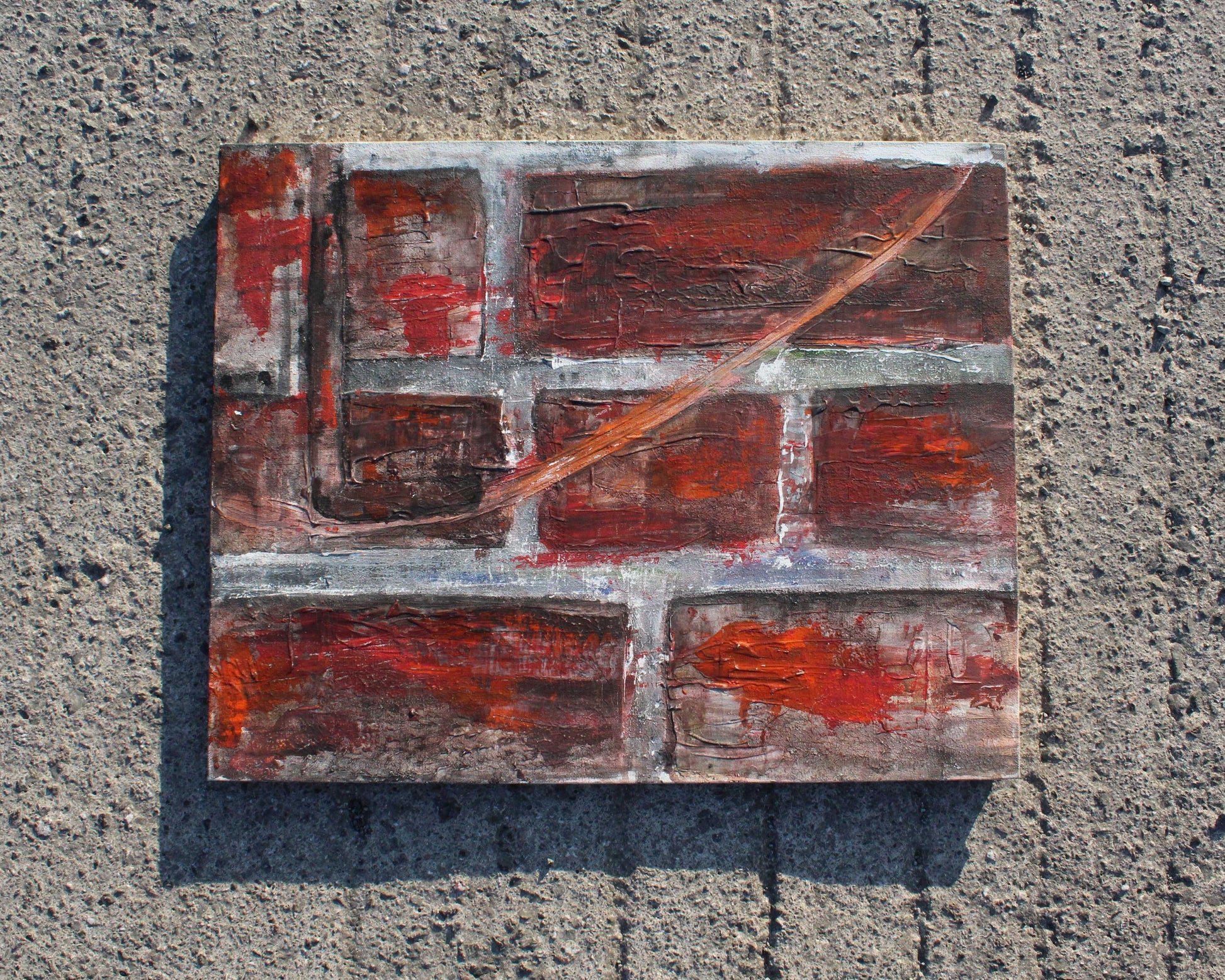 Abstract painting with red and brown tones on a textured surface